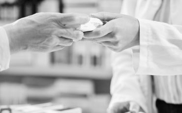Shot of a pharmacist handing a customer a box of medication in a chemist