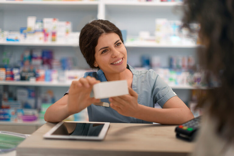 Farmacéutica en una farmacia entregando medicamento